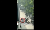 女子跳楼居民楼下用被子围接 一施救者被跳楼者砸成重伤